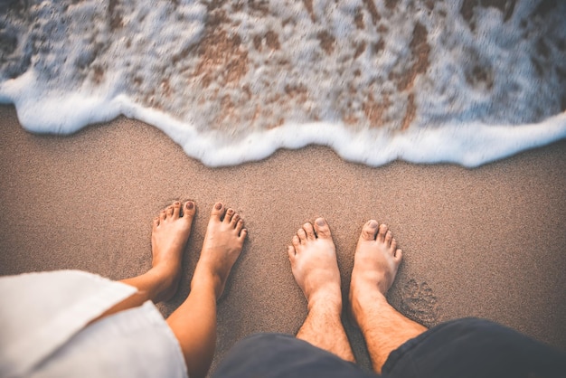 Viajero pareja hombre y mujer pie en la playa