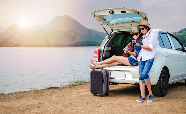 Viajero de pareja sentada en el coche de la ventana trasera y disfrutando de la vista de la naturaleza