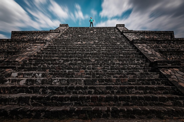 Un viajero de pie en la cima de la pirámide de Teotihuacan