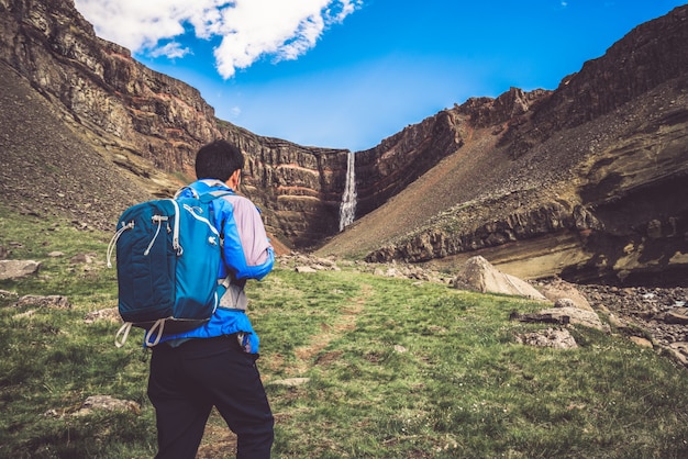 Viajero que camina en la cascada de Hengifoss, Islandia.