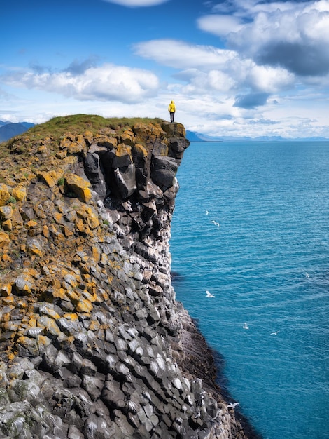 Viajero en las rocas altas de Islandia Viajes y aventuras Rocas y océano Paisaje natural en verano Islandia e imagen turística