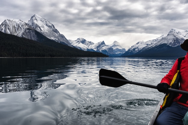 Viajero rojo piragüismo y montaña rocosa en el lago maligne