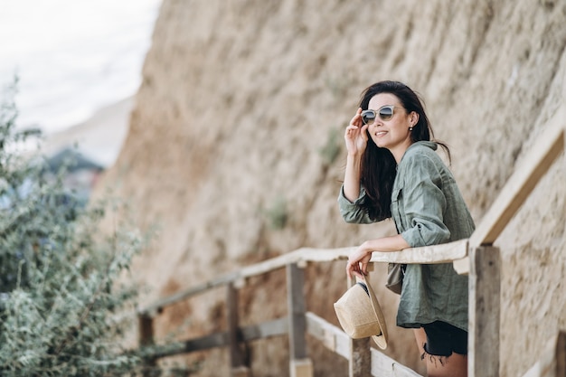 Viajero con sombrero y gafas de sol con rocas detrás