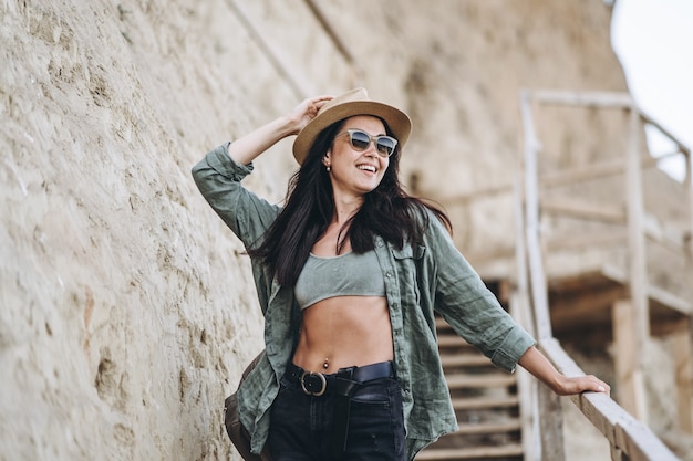 Viajero con sombrero y gafas de sol con rocas detrás