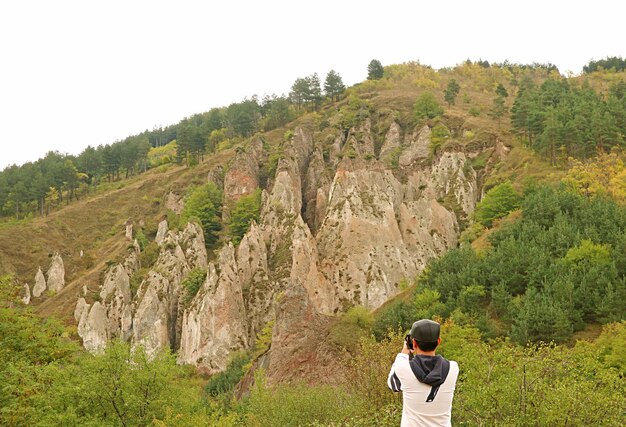 Viajero tomando fotos de fantásticas formaciones rocosas en Old Khndzoresk Cave Village en Syunik Armenia