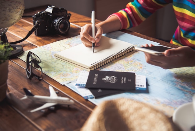 Los viajeros están planeando un viaje buscando la ruta en el mapa y buscando información en Internet.