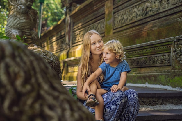 Viajeros de mamá e hijo descubriendo el bosque de Ubud en el bosque de los monos, Bali, Indonesia. Concepto de viajar con niños.