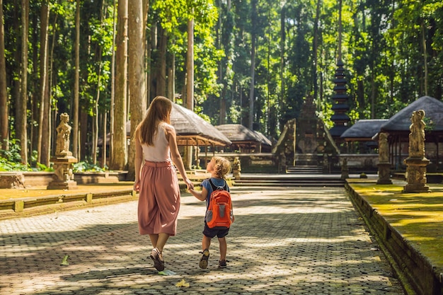 Viajeros de mamá e hijo descubriendo el bosque de Ubud en el bosque de los monos Bali Indonesia Viajando con el concepto de niños