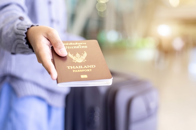 Viajeros mostrando su pasaporte de Tailandia en el aeropuerto