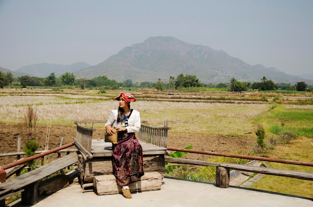 Viajeros mujer tailandesa con traje tradicional de la etnia Tai Dam para tomar una foto con la montaña del campo de arroz del paisaje en Thai Dam Cultural Village en Chiang Khan en Loei Tailandia
