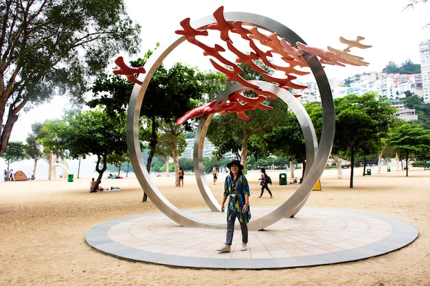 Los viajeros mujer tailandesa viajan y posan para tomar una foto con el monumento Art en la playa de Repulse Bay el 9 de septiembre de 2018 en Hong Kong, China