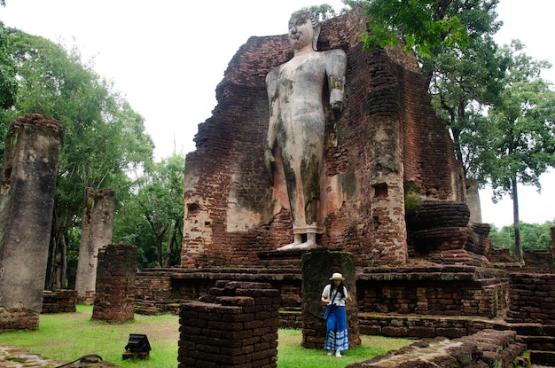 Los viajeros, una mujer tailandesa, visitan a pie y viajan, toman fotos en un edificio antiguo y las ruinas del Parque Histórico Kamphaeng Phet es un sitio arqueológico y el Área Aranyik en Kamphaeng Phet Tailandia