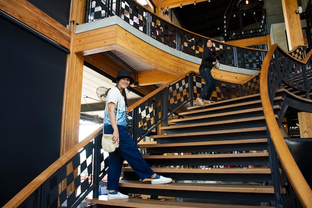 Viajeros mujeres tailandesas caminando por las clásicas escaleras de madera en un restaurante moderno y lujoso en Bangkok Tailandia