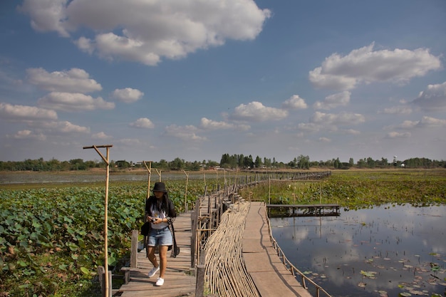 Viajeros mujeres tailandesas viajan visitan y posan retratos para tomar fotos en el largo puente de madera Kae Dam en la provincia de Maha Sarakham, al noreste de Tailandia