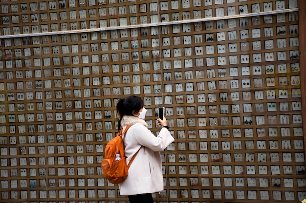 Viajeros mujeres tailandesas viajan visitan y toman aretes de accesorios de recuerdo de variedad de fotos en la pared de la tienda de regalos en Nampo dong o Gwangbok dong en Nampodong el 18 de febrero de 2023 en Busan Corea del Sur