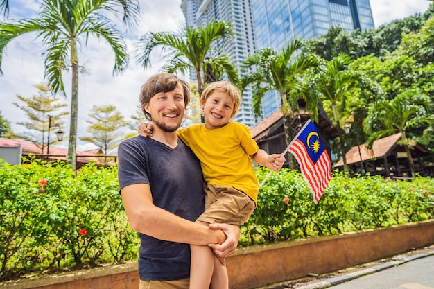 Viajeros de padre e hijo en malasia con la bandera de malasia celebrando el día de la independencia de malasia y el concepto de viaje del día de malasia a malasia