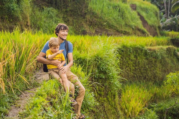 Viajeros de papá e hijo en hermosas terrazas de arroz en el contexto de volcanes famosos en Bali Indonesia Concepto de viaje con niños