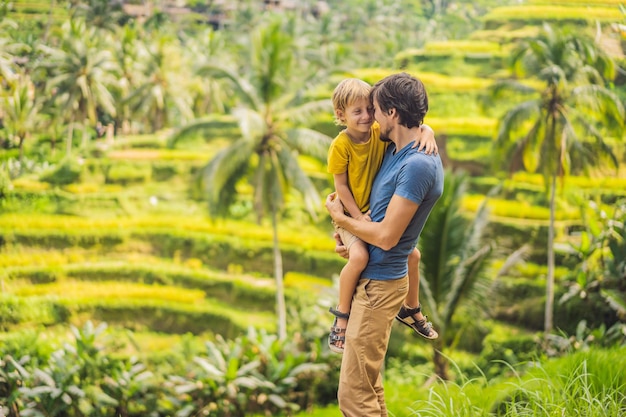 Viajeros de papá e hijo en hermosas terrazas de arroz en el contexto de volcanes famosos en Bali Indonesia Concepto de viaje con niños