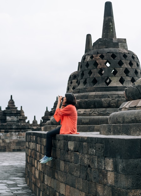 Los viajeros solitarios femeninos asiáticos toman los edificios antiguos de la foto en el templo de Borobudur, Java, Indonesia