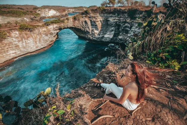 Viajes mujer mirando vista de playa rota, isla de Nusa Penida Bali, Indonesia