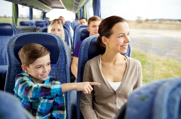 viajes, turismo, familia, tecnología y concepto de personas - feliz madre e hijo viajando en autobús de viaje