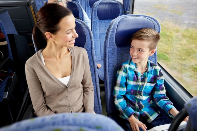 viajes, turismo, familia, tecnología y concepto de personas - feliz madre e hijo viajando en autobús de viaje