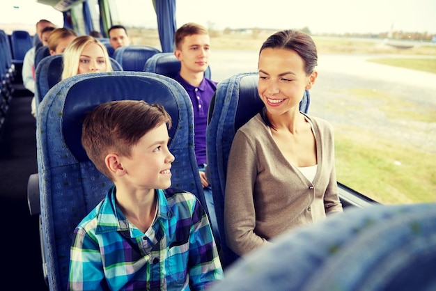 viajes, turismo, familia, tecnología y concepto de personas - feliz madre e hijo viajando en autobús de viaje