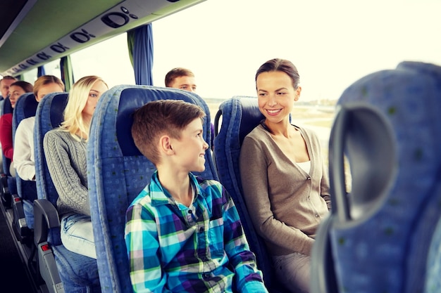 Foto viajes, turismo, familia, tecnología y concepto de personas - feliz madre e hijo viajando en autobús de viaje