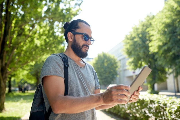 viajes, turismo, mochileros, tecnología y concepto de personas - hombre que viaja con mochila y tablet pc en la ciudad buscando ubicación