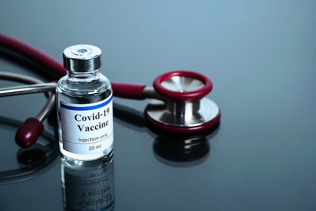 Vial de vacuna de coronavirus Covid19 con estetoscopio en inmunización de laboratorio médico y tratamiento de c