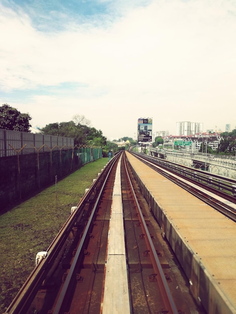 Foto las vías del ferrocarril en la ciudad contra el cielo