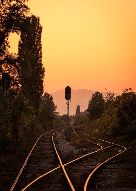 Foto las vías del ferrocarril contra el cielo naranja