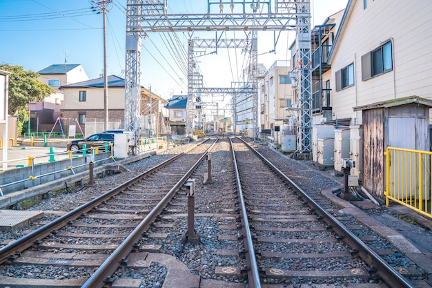 Vías de ferrocarril japonesas locales con estacionamiento para el hogar y el automóvil al lado