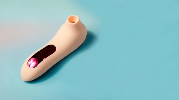 Vibrador de onda de vacío rosa para estimulación del clítoris Juguete sexual para mujeres sobre un fondo azul claro Producto de tienda sexual para adultos espacio para texto