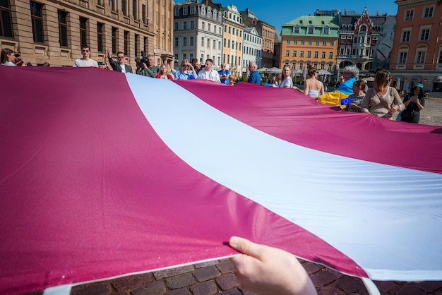 Foto vibrante celebración con bandera letona en el casco antiguo de riga