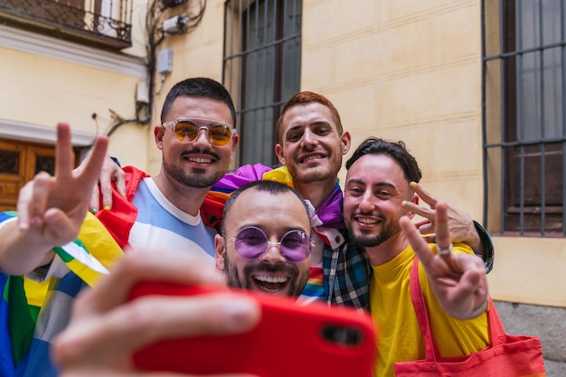 Vibrante Gay Friendship Quatro homens alegres adornados com roupas LGBTQ capturam o momento saindo de casa