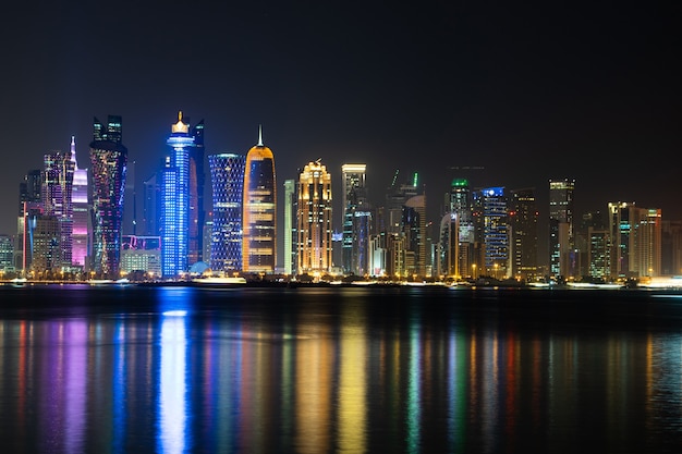 Vibrante horizonte de Doha por la noche, visto desde el lado opuesto de la bahía de la ciudad capital por la noche.