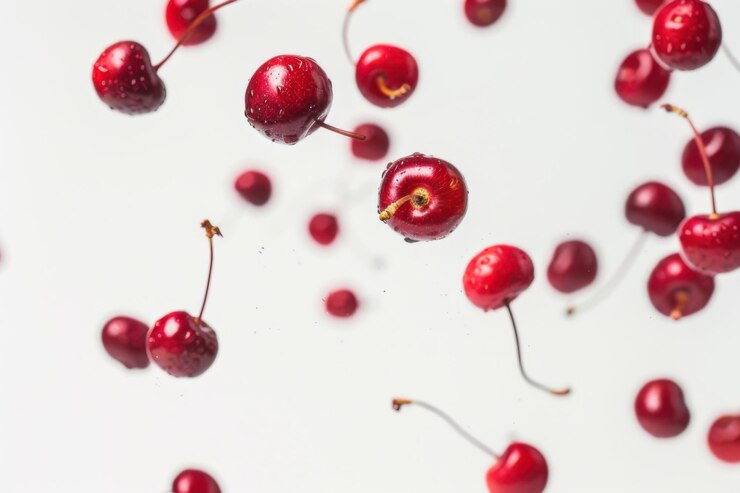 Un vibrante racimo de cerezas frescas con tallos artísticamente dispuestos contra un fondo claro