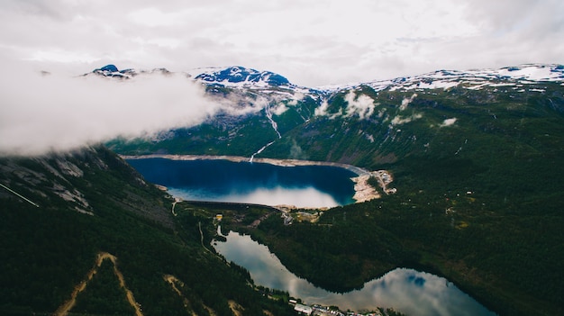 Vibrierende Ansicht des schönen Sommers auf berühmtem norwegischem touristischem Platz - trolltunga, die Schleppangelzunge mit einem See und Berge, Norwegen, Odda.