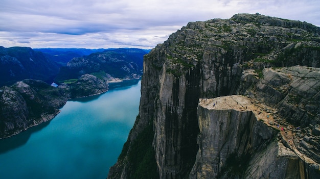 Vibrierende Ansicht des schönen Sommers auf berühmtem norwegischem touristischem Platz - trolltunga, die Schleppangelzunge mit einem See und Berge, Norwegen, Odda.