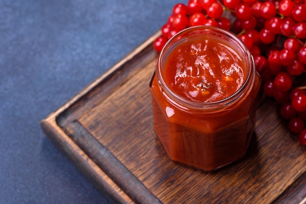 Viburnum-Fruchtmarmelade in einem Glasgefäß auf dunklem Betonhintergrund