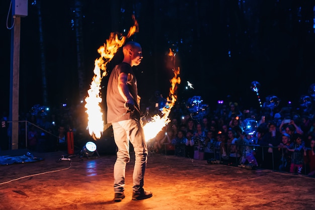 VICHUGA, Rusia - 17 de junio de 2018: espectáculo de fuego, un hombre fakir agitando antorchas encendidas