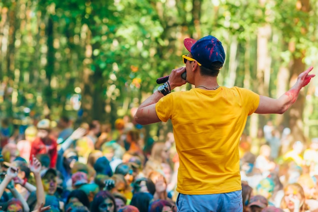 VICHUGA, RUSSLAND - 17. JUNI 2018: Mannführung steht auf dem Stadium an der Feier des Festivals von Farben Holi