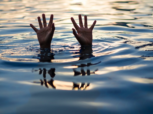 Víctimas de ahogamiento, mano de hombre ahogado que necesita ayuda.