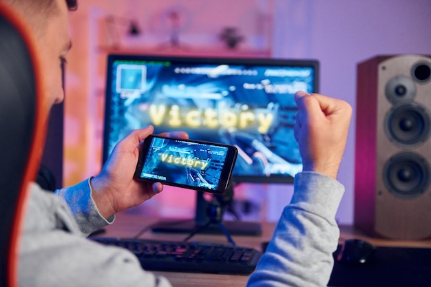 Victory happy man celebrando streamer online jogando jogo de tiro fps em casa