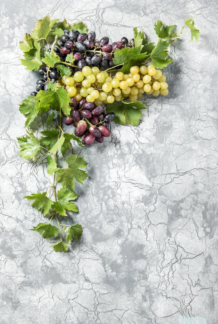 Foto vid de uva con hojas verdes sobre fondo de alimentos de textura de piedra de hormigón