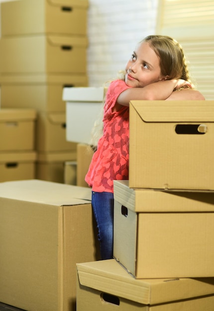 La vida acaba de mejorar niño feliz caja de cartón Concepto de mudanza nuevo apartamento Cajas de cartón mudarse a una casa nueva niña feliz compra de una nueva vivienda