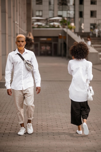 Vida en la ciudad. Dos jóvenes vestidos de blanco caminando por la calle