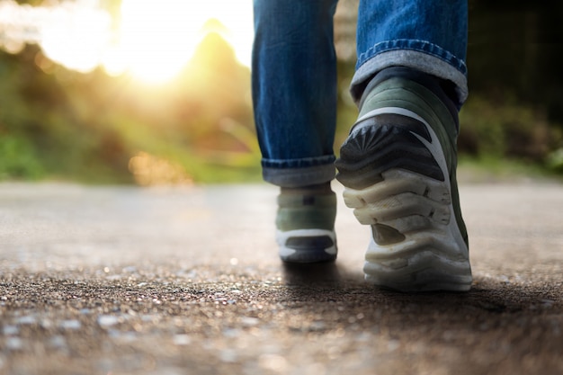 Vida y concepto desafiante. Sección baja del joven motivado caminando al aire libre. Luz solar natural