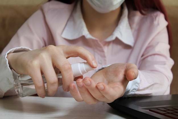 Foto la vida en coronavirus en cuarentena. educación a distancia en línea. una colegiala con una máscara limpiando sus manos con gel desinfectante. pandemia de coronavirus en el mundo.